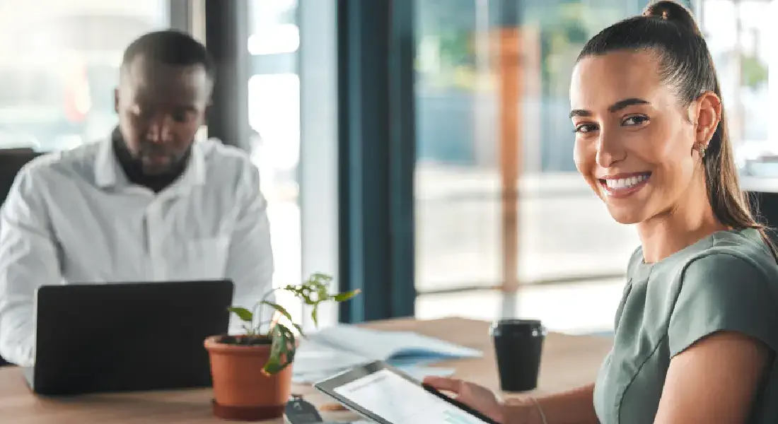 Two professionals discussing strategies with a laptop on the table at an SEO service company