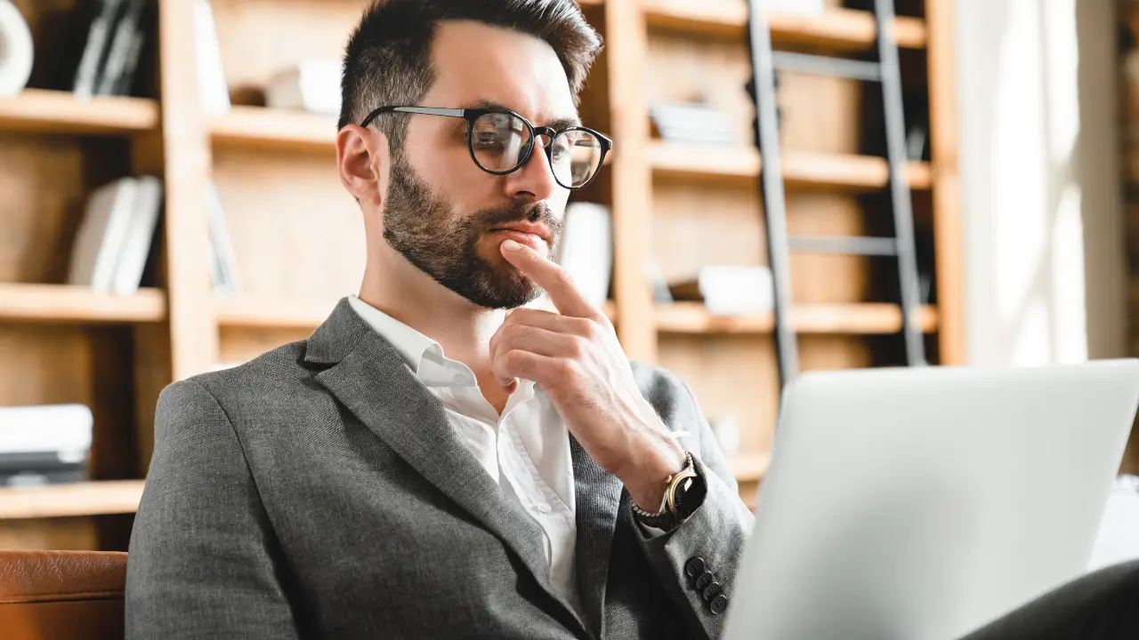 Business professional reviewing AI generated insights and data visualizations on a laptop in a modern office